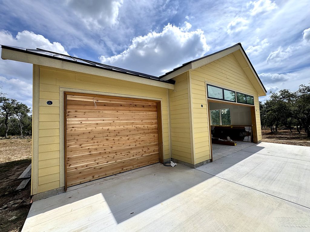 Real photo of the cedar garage door and transom windows on the garage wing of 168 Crooked Creek Court, September 2026
