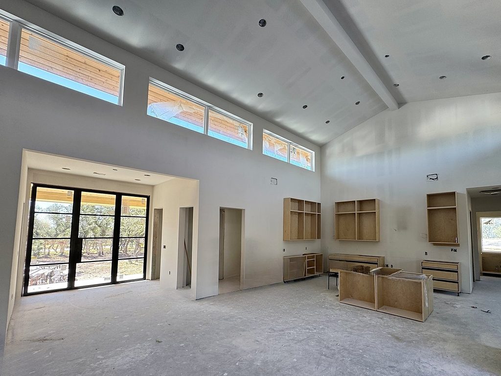 Real photo of the beamed vaulted ceiling over the great room and kitchen as cabinetry goes in at 168 Crooked Creek Court, October 2026