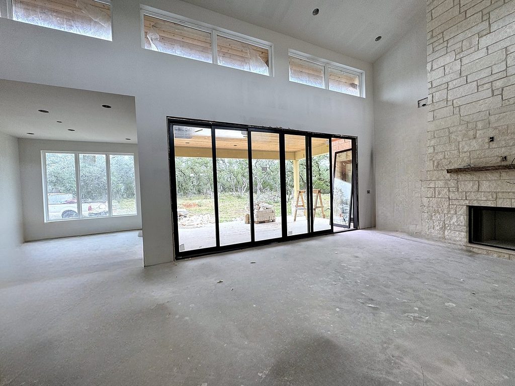 Real photo of the great room opening to the back porch through black-framed sliding doors at 168 Crooked Creek Court, October 2026